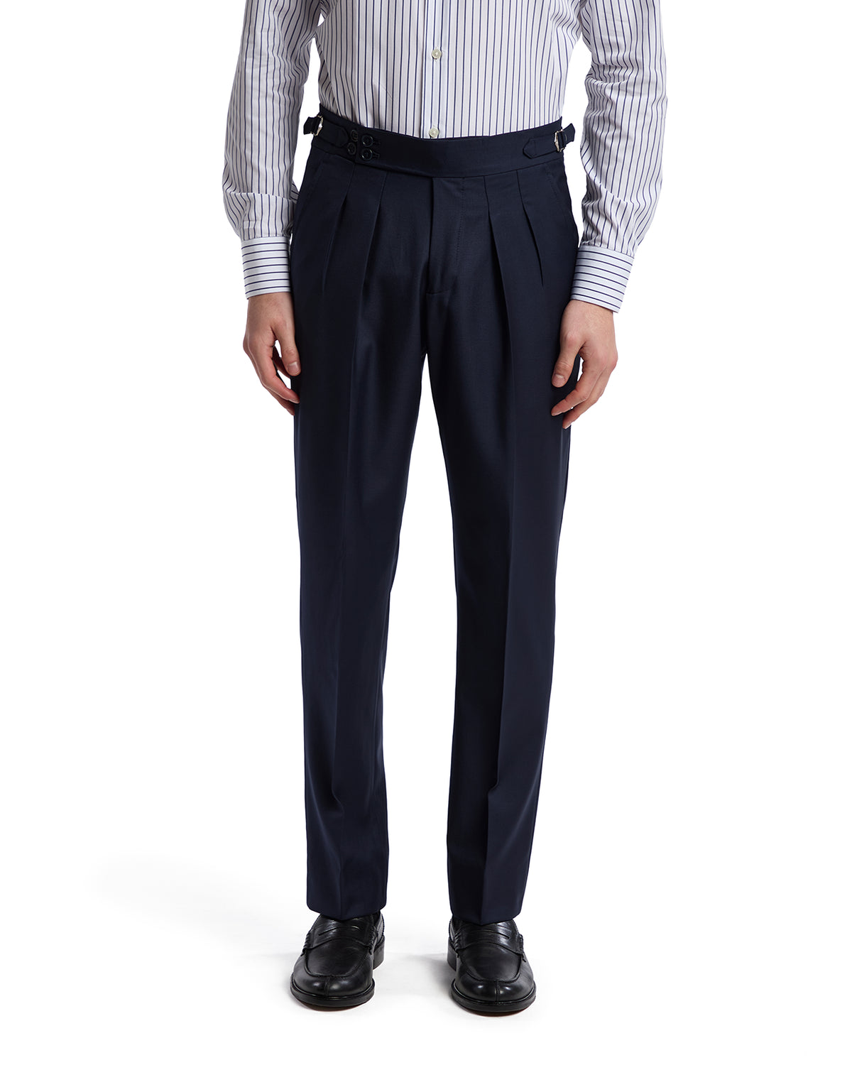 Navy pleated dress pants with adjustable straps, paired with a striped shirt for a sophisticated look.