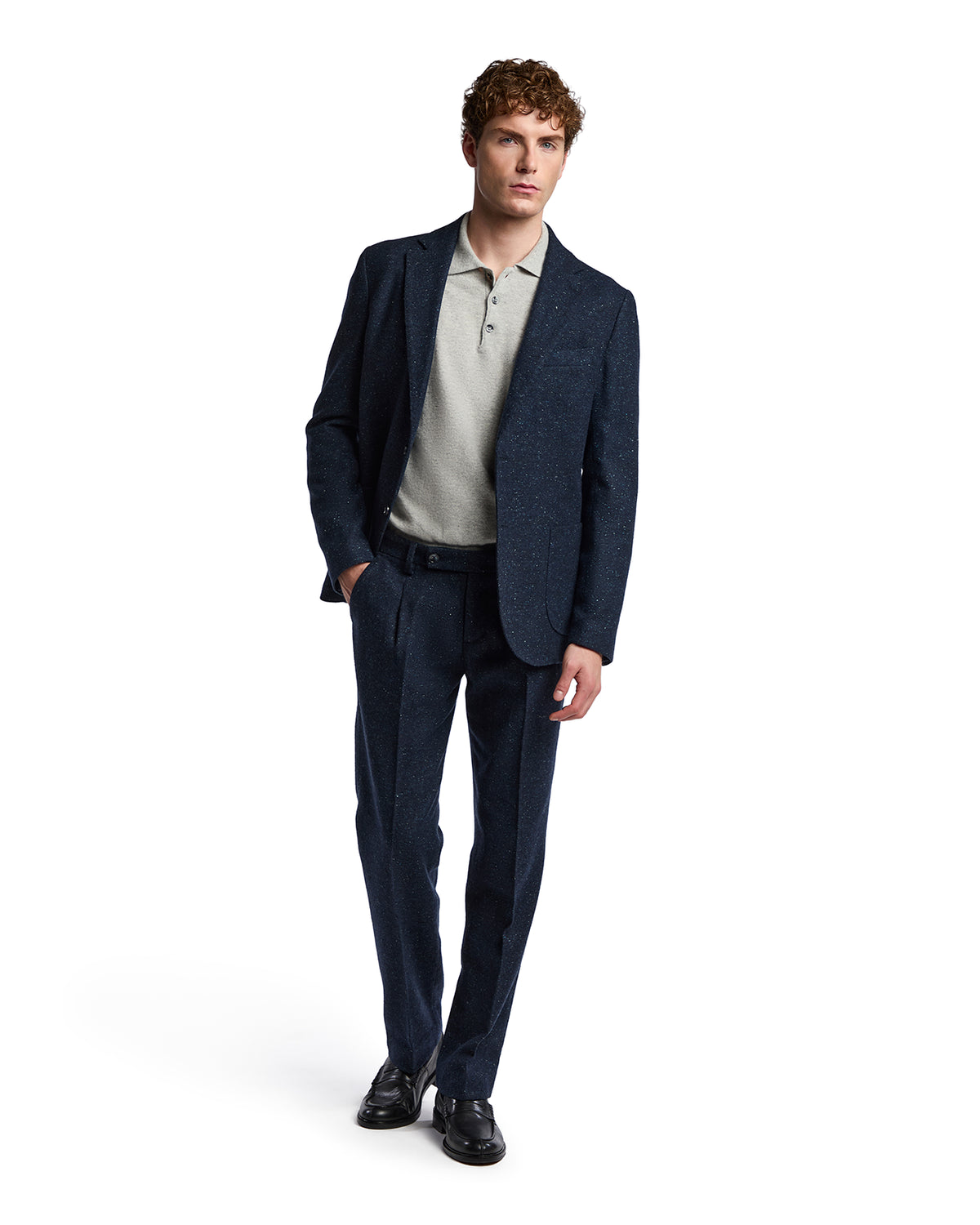 Men's dark navy tailored suit with a textured finish, paired with a light gray polo shirt, modern fit.