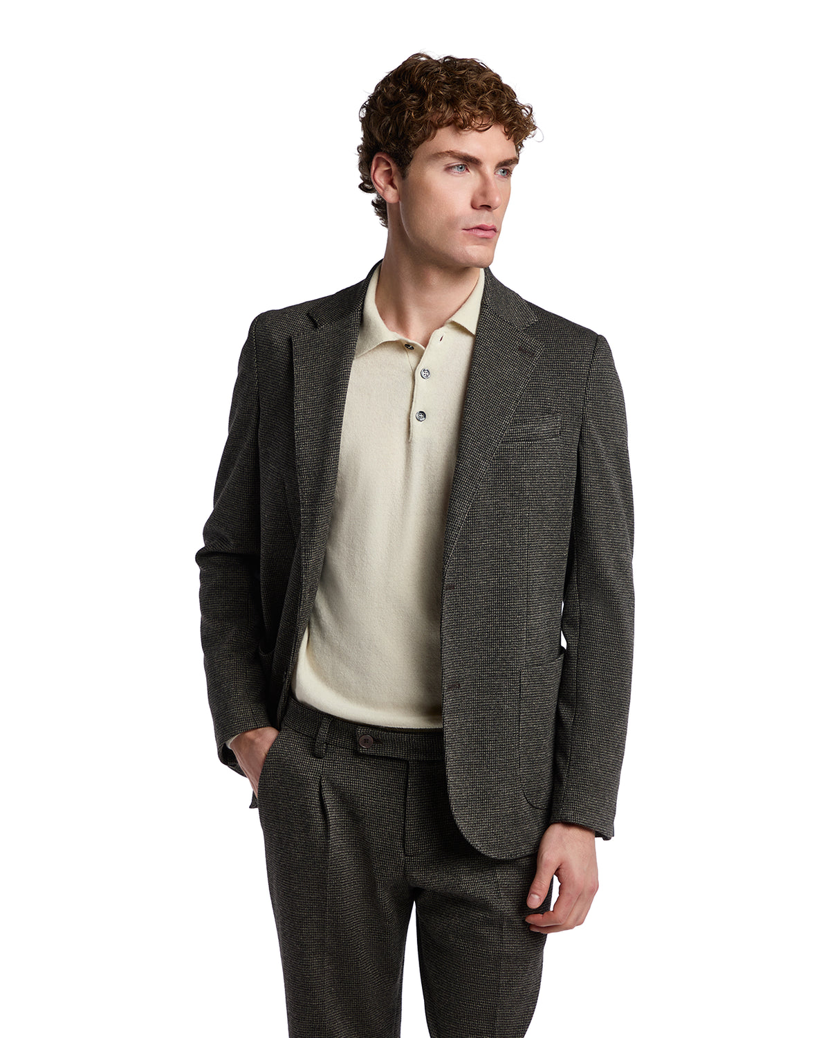Men's tailored charcoal gray wool suit jacket paired with a beige polo shirt for a sophisticated, smart-casual look.