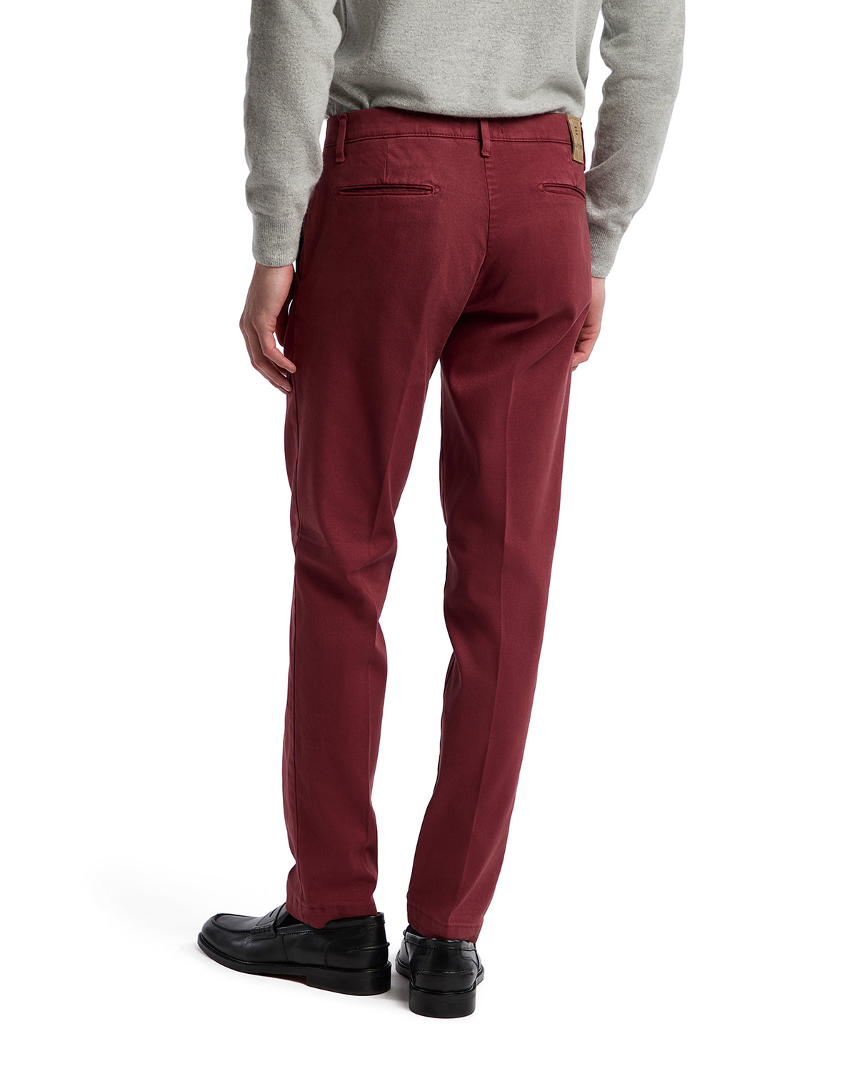 Men's burgundy cotton-chino trousers, slim fit, featuring a smooth finish and back pockets, paired with a gray sweater.
