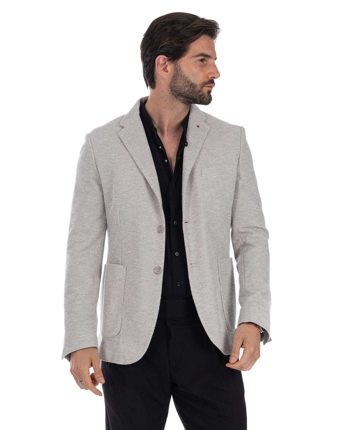 Men's light gray textured wool blend blazer with notched lapels, patch pockets, and two-button closure, paired with black.