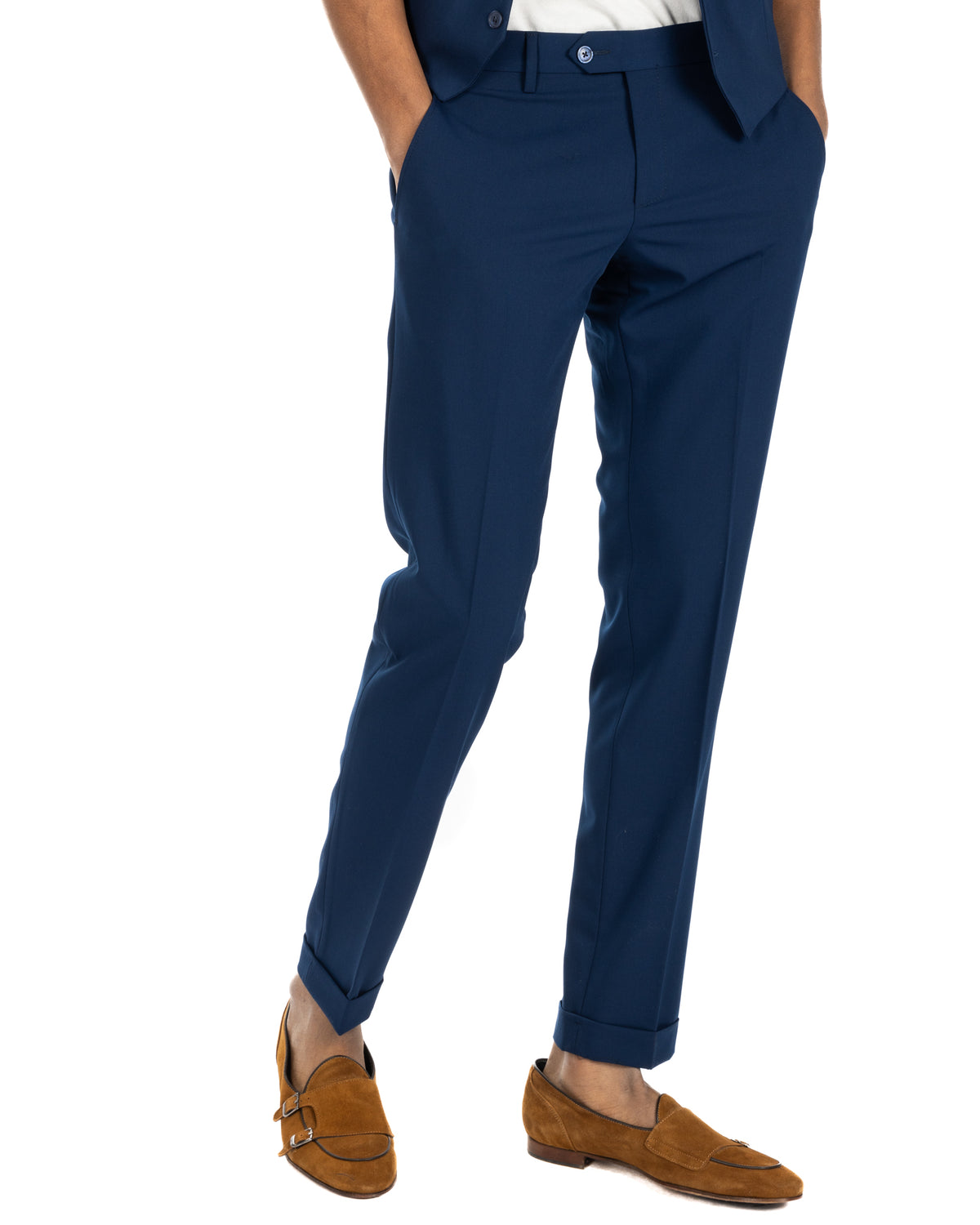 Navy blue slim fit suit trousers with cuffed hems, paired with tan suede monk strap loafers.