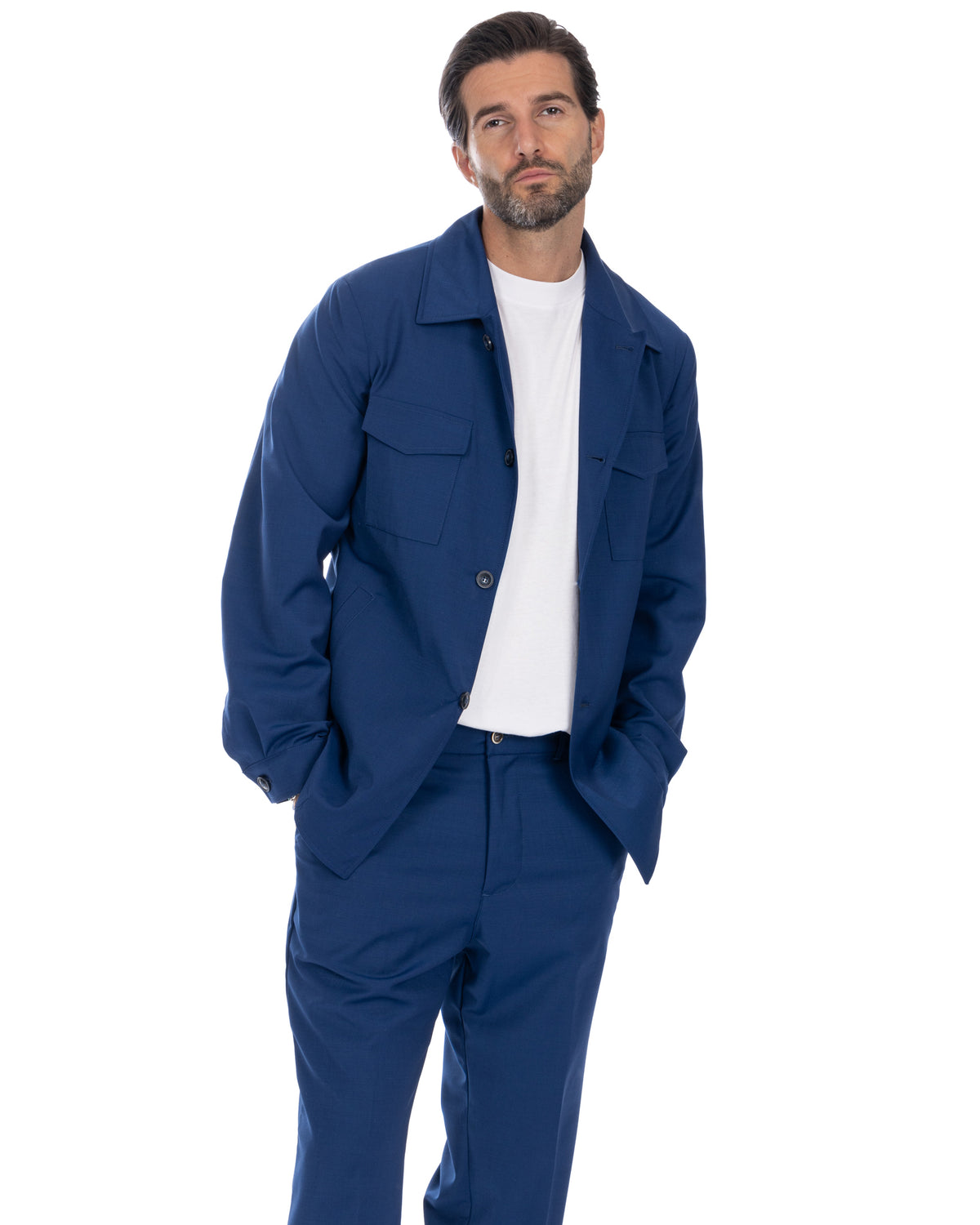 Men's navy blue cotton twill utility suit with button-front jacket, flap pockets, and matching trousers over white tee.