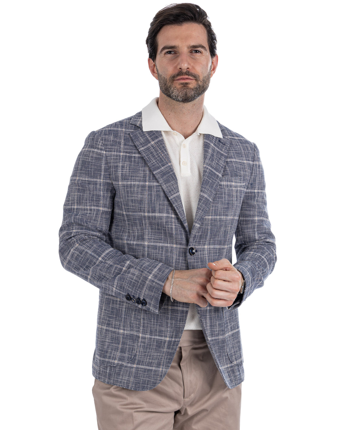Men's blue plaid linen blazer with white windowpane check, paired with beige trousers and white polo shirt.
