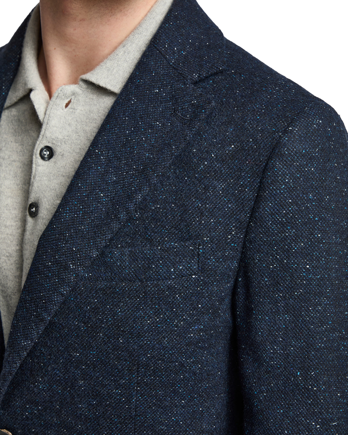 Navy blue tweed blazer with a textured finish, paired with a light grey polo shirt for a stylish, modern look.