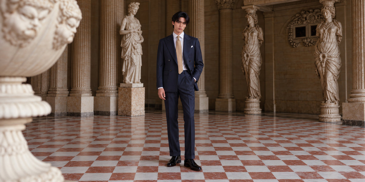 Elegant navy blue tailored suit featuring a slim fit, paired with a white dress shirt and polished black shoes.