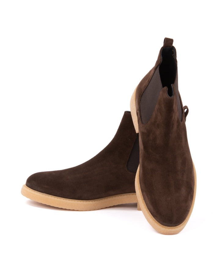Brown suede Chelsea boots with gum rubber soles, featuring a sleek ankle design and elastic side panels.