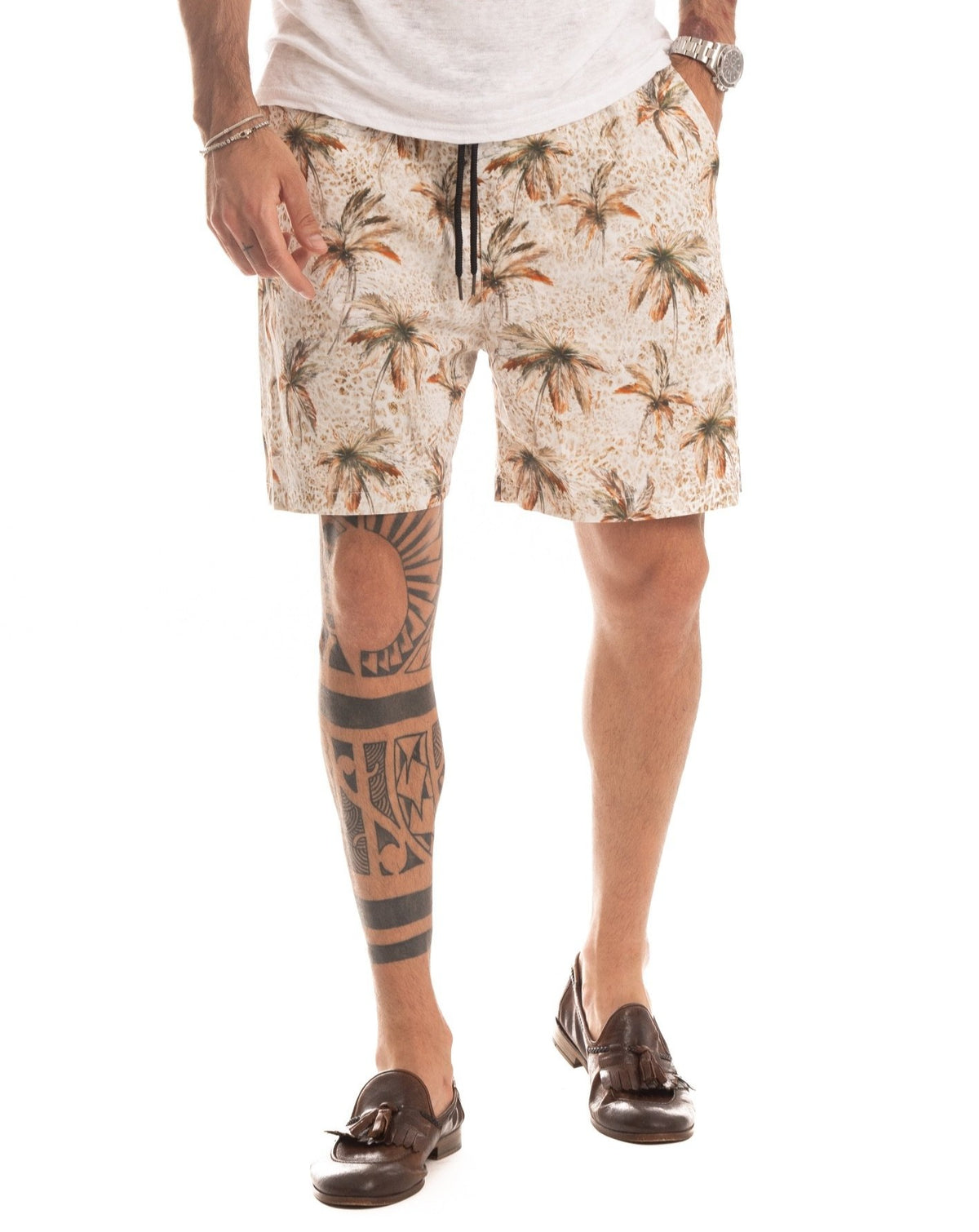 Beige drawstring shorts with an all-over palm tree print, front view on a model