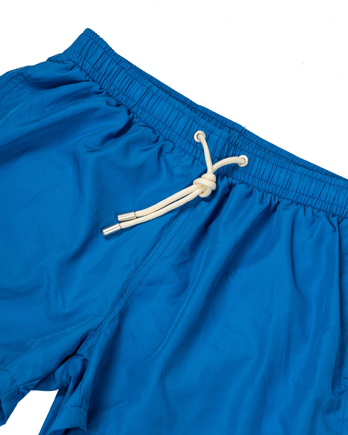 Blue swim shorts with elastic drawstring waistband and welt back pocket, laid flat