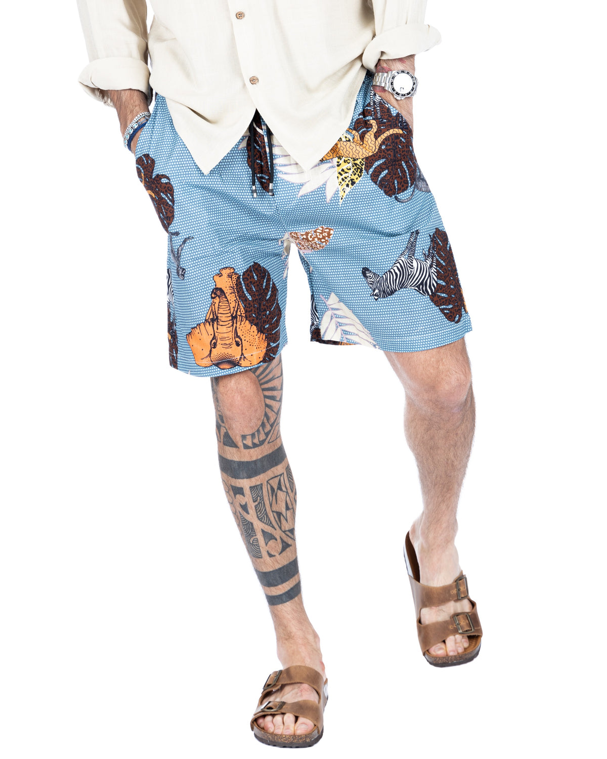 Men's light blue drawstring shorts with safari animal print featuring elephants and zebras, shown on a model