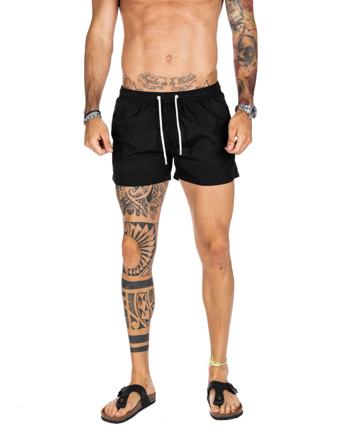 Men's black swim shorts with white drawstring and elastic waistband, shown on a model
