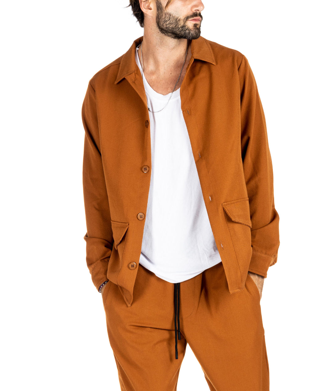 Men's burnt orange overshirt worn open over a white ribbed tank top, shown on a model