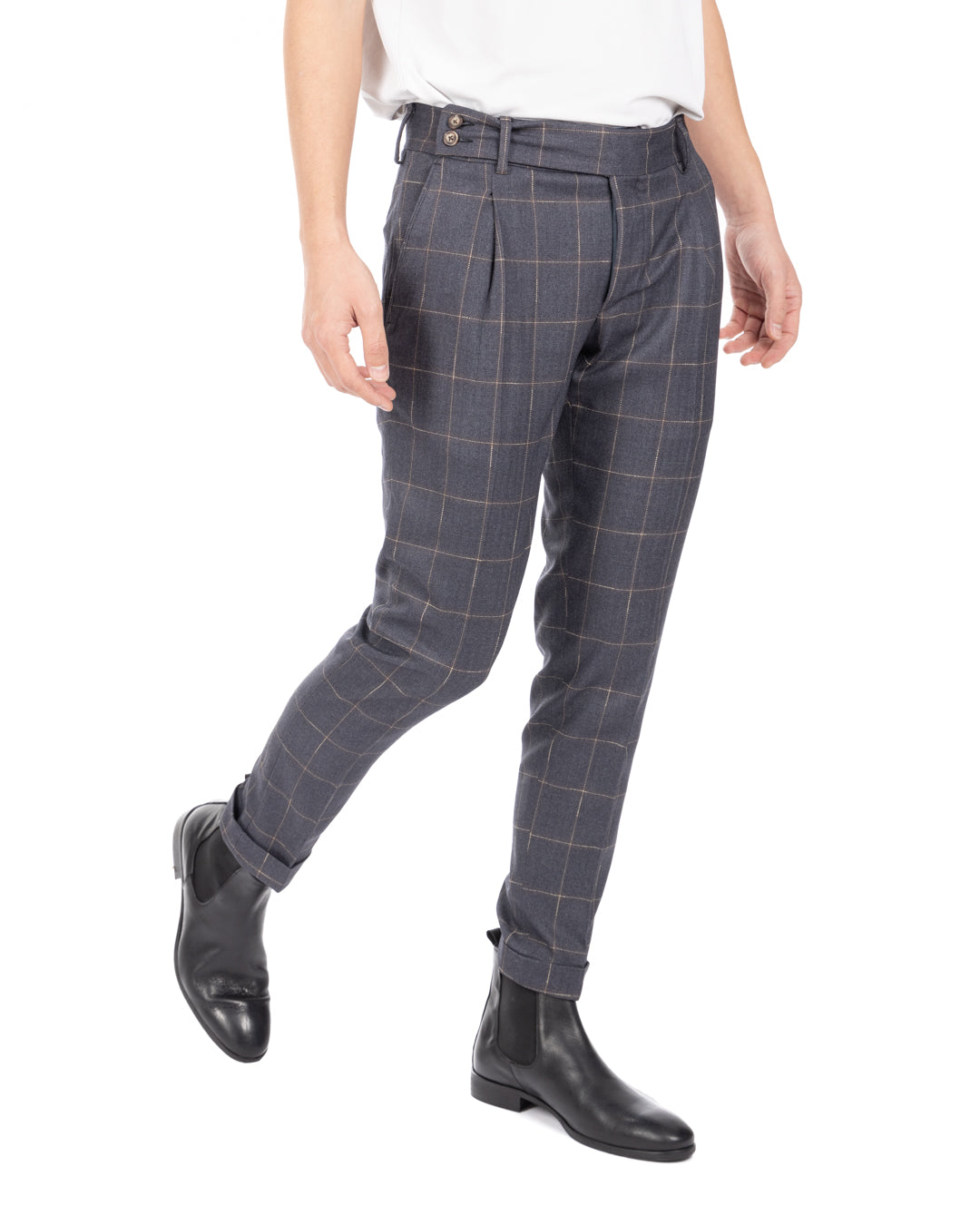 Men walking in blue-gray windowpane check pleated wool trousers with cuffed hems and black leather Chelsea boots, side view