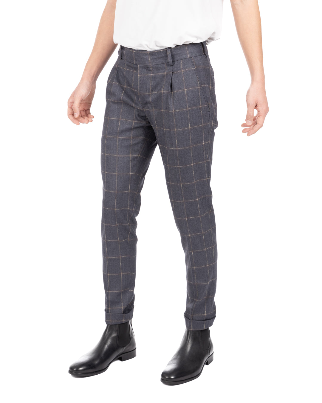 Men's blue-gray windowpane check pleated wool trousers worn with a white t-shirt and black leather Chelsea boots, front view