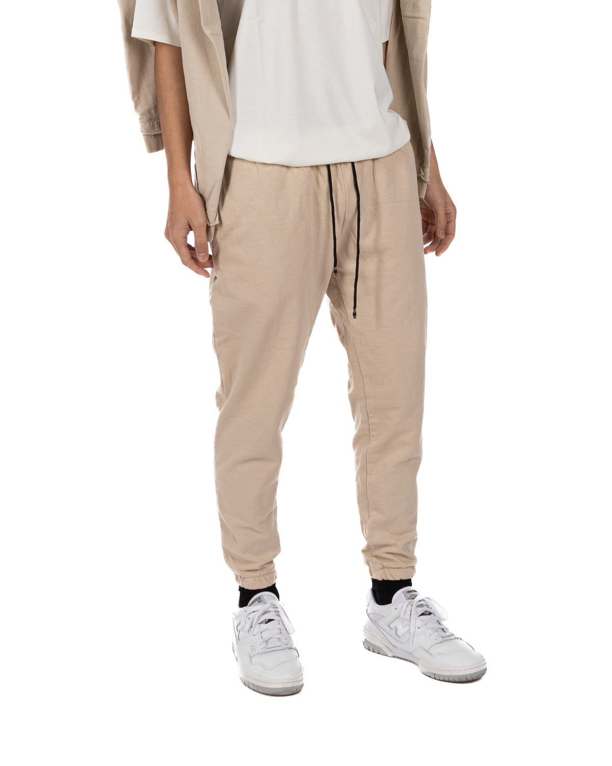 Front view of men's beige cotton drawstring jogger pants with tapered leg and elastic ankle cuffs