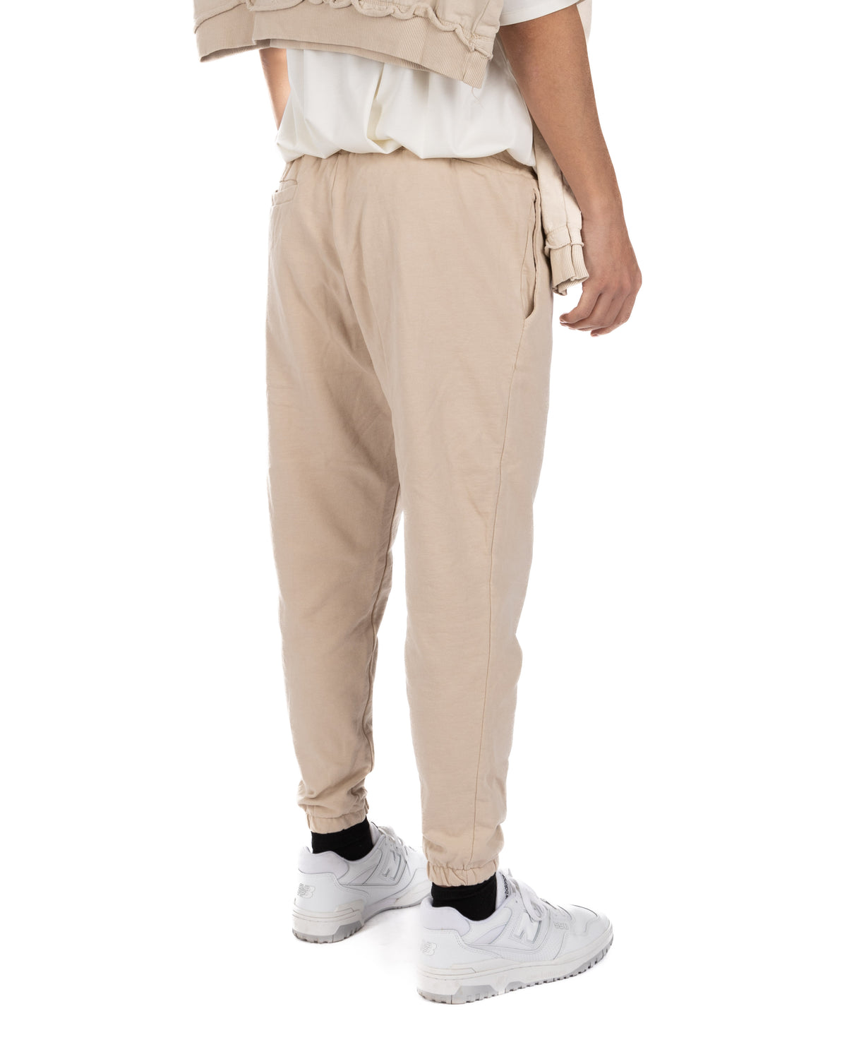 Back view of men's beige cotton jogger pants with elastic waistband and cuffed hems