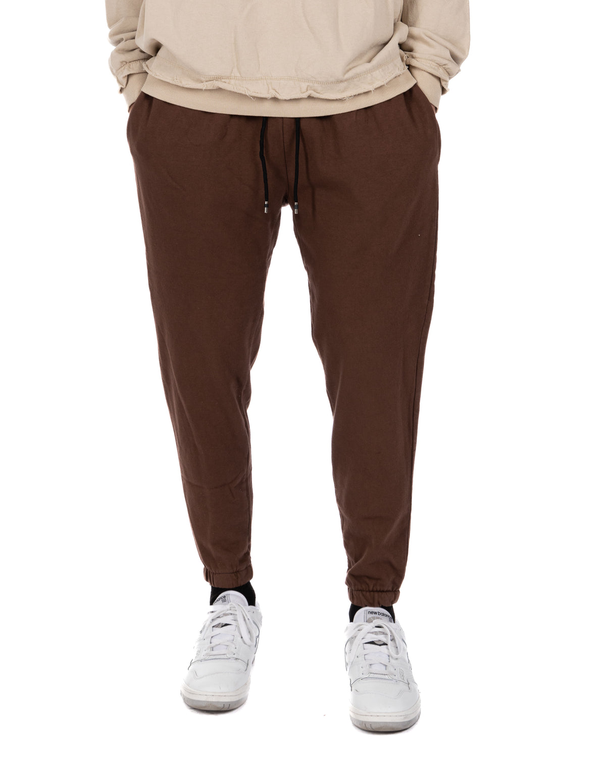 Brown cotton jogger pants with drawstring waist, cuffed ankles. Casual athletic style sweatpants for men.