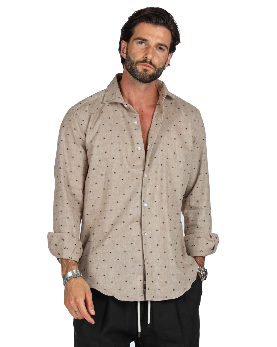 Men's beige linen shirt with brown dot pattern, shown on a model with hands in pockets