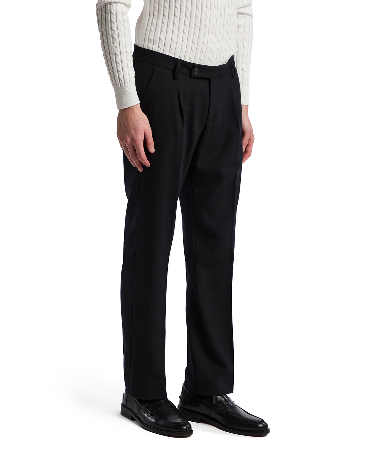 Men's black tailored dress pants in wool blend, featuring a classic fit and front pleats, styled with a white knit sweater.