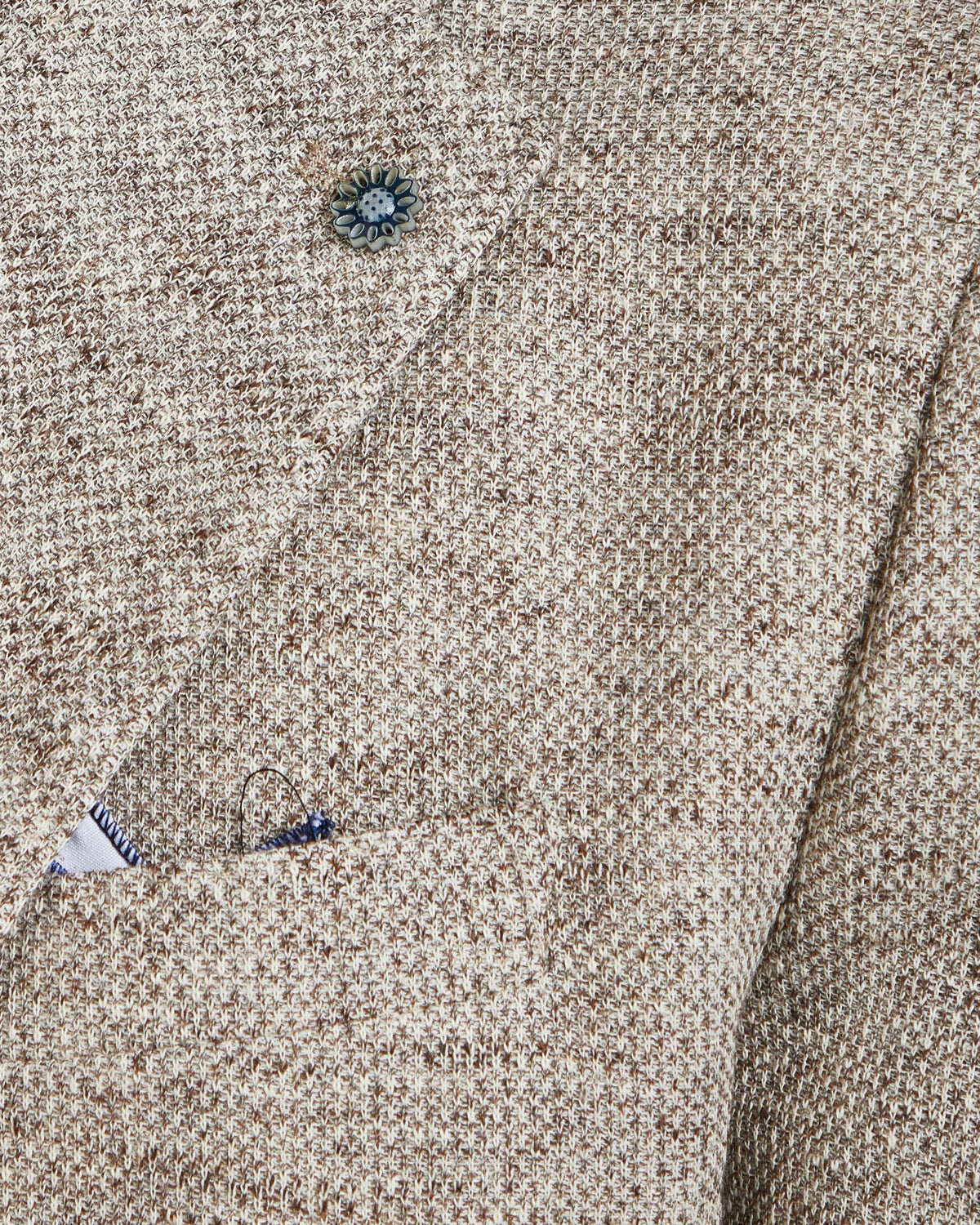 Beige textured blazer with a subtle pattern, featuring a single button and a stylish breast pocket.