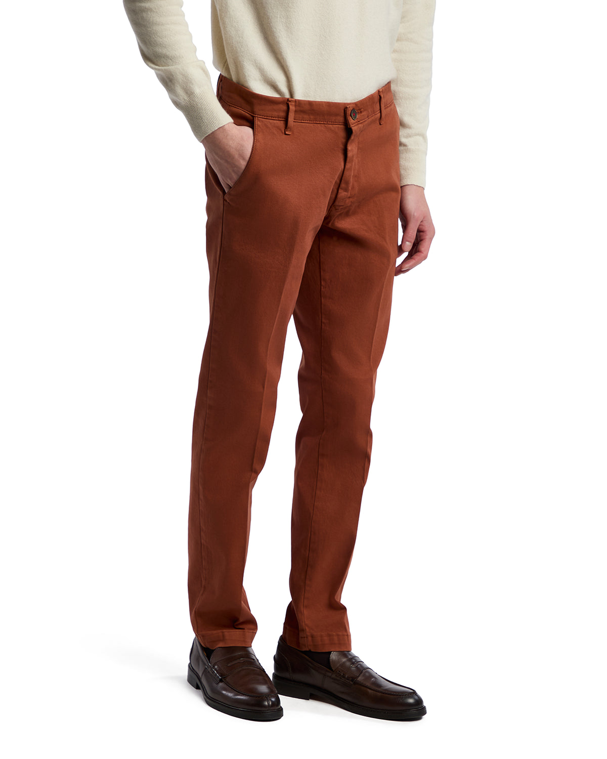 Men's rust-colored cotton chinos, tailored fit, with side pockets and belt loops, paired with black dress shoes.