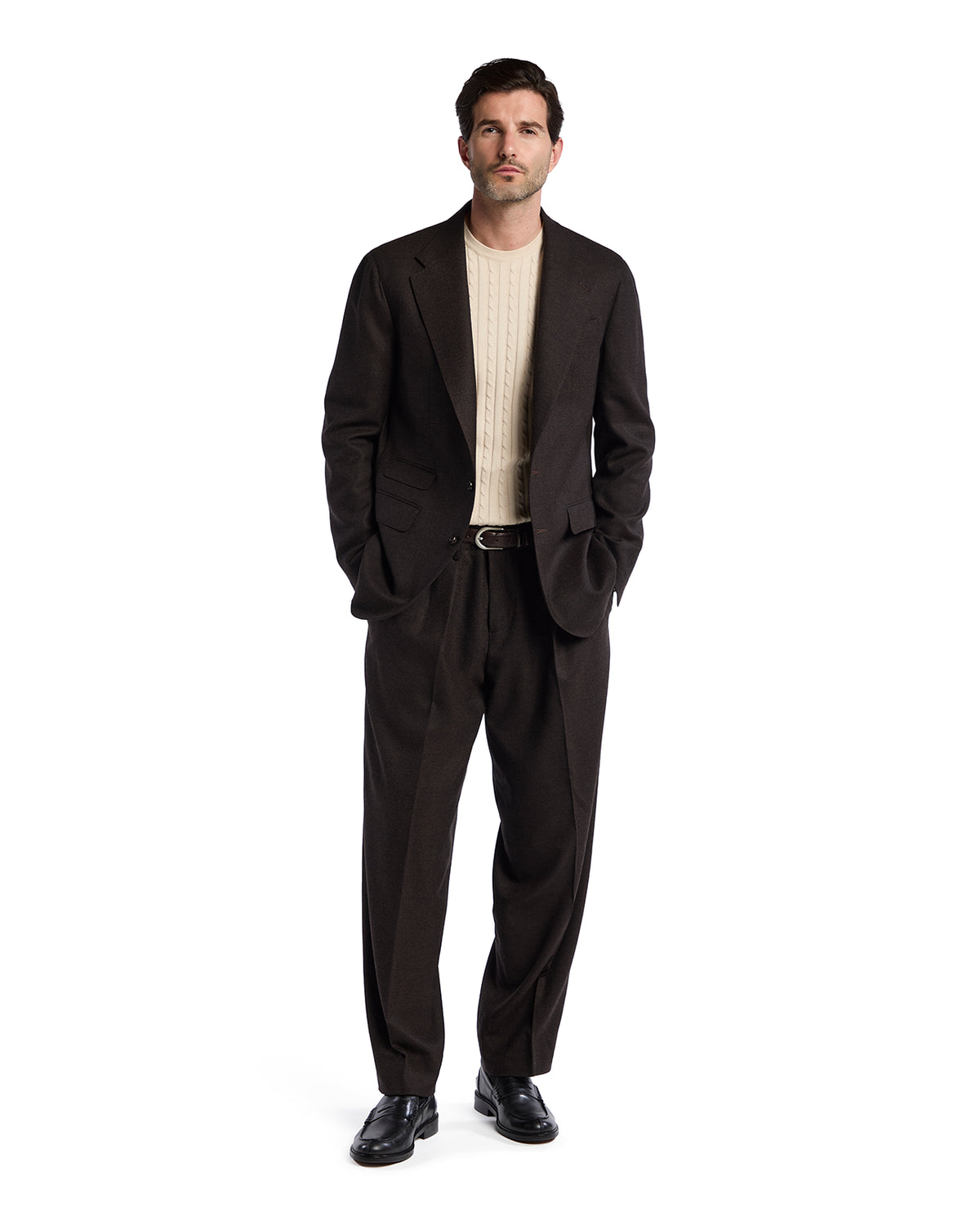 Men's dark brown tailored suit with a cream cable-knit sweater, styled for a smart-casual look.