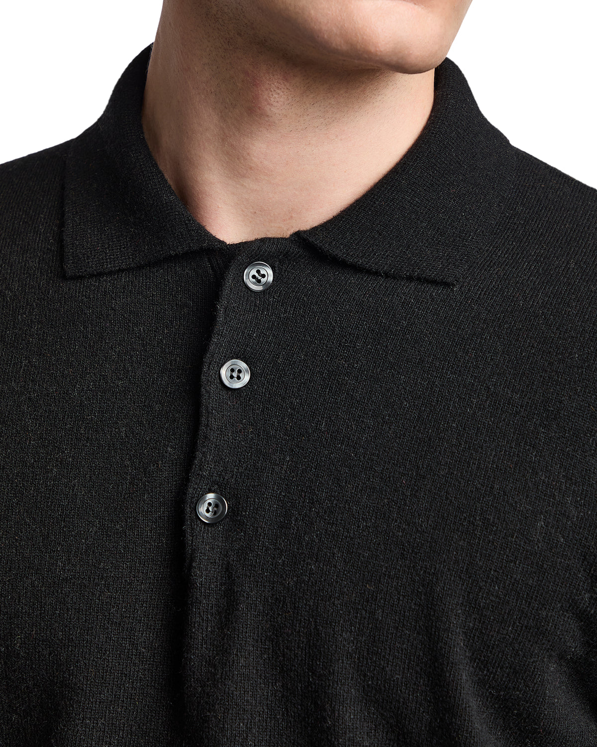 Black knit polo shirt with a classic collar and button placket, featuring five buttons for a stylish look.