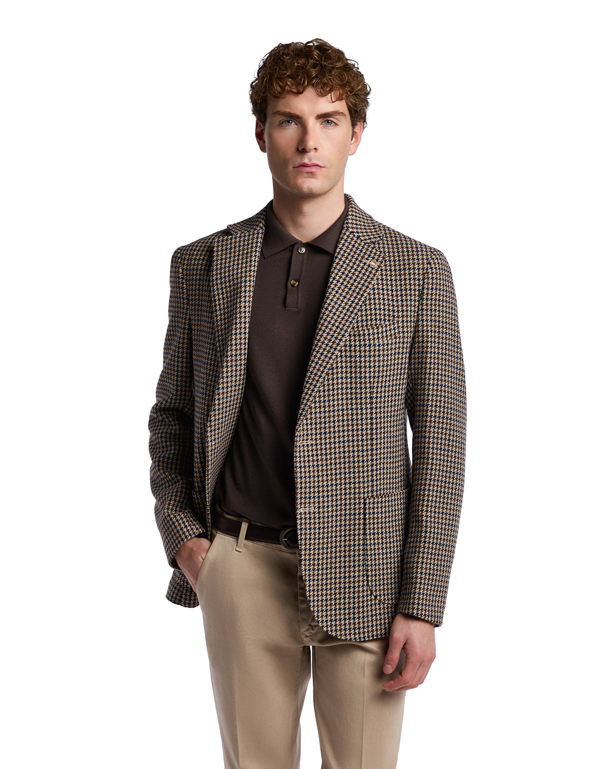 Men's brown houndstooth blazer in wool blend, styled with a dark polo and beige trousers for a sophisticated look.
