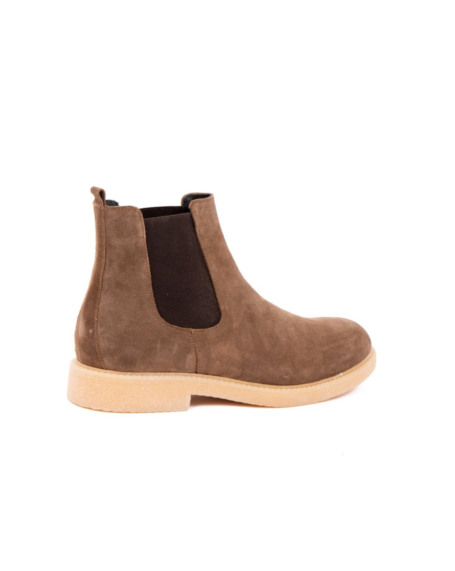 Brown suede Chelsea boots with black elastic side panels and a beige rubber sole. Stylish and versatile footwear.