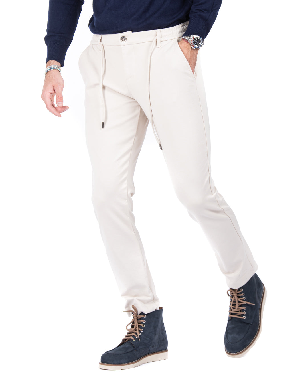 Men's cream joggers in soft cotton with side pockets, paired with navy suede boots for a stylish, casual look.