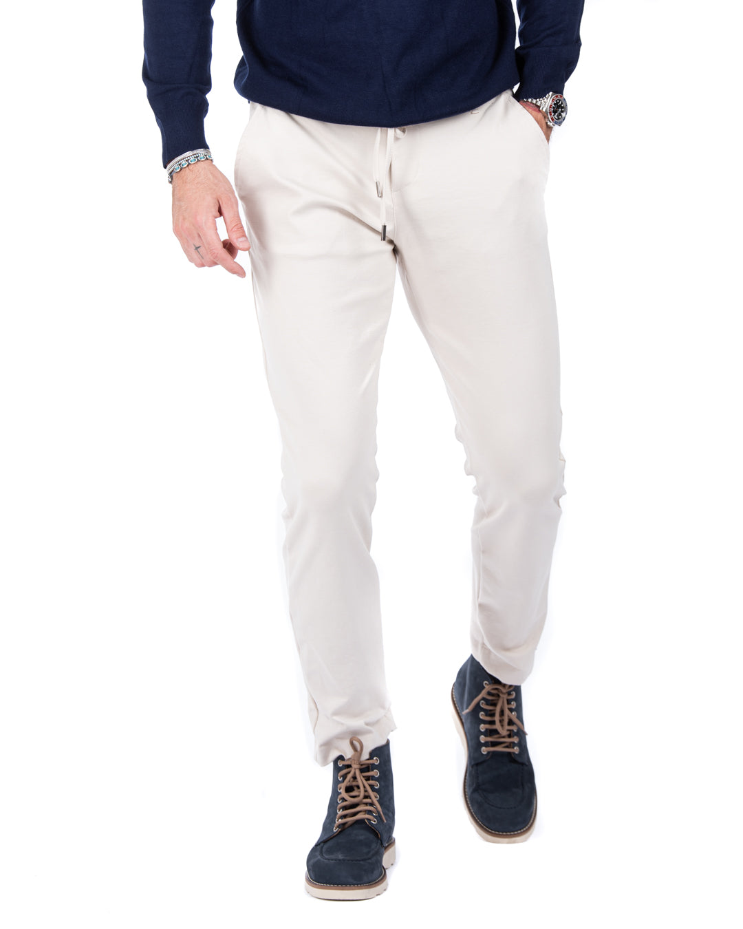 Beige lightweight pants for men, featuring a slim fit and drawstring waist, paired with navy blue sneakers.