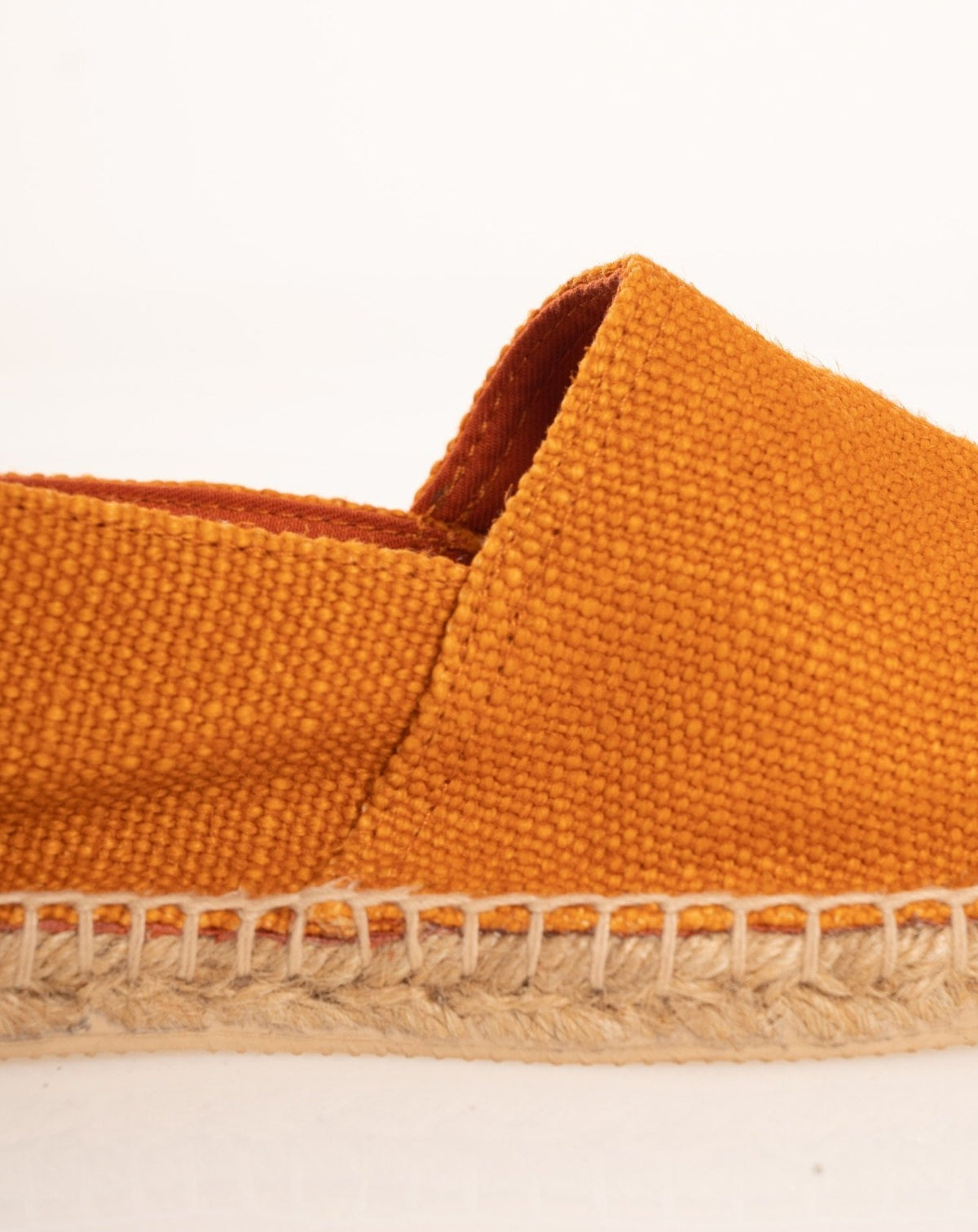 Detail view of the woven orange canvas upper with red inner lining