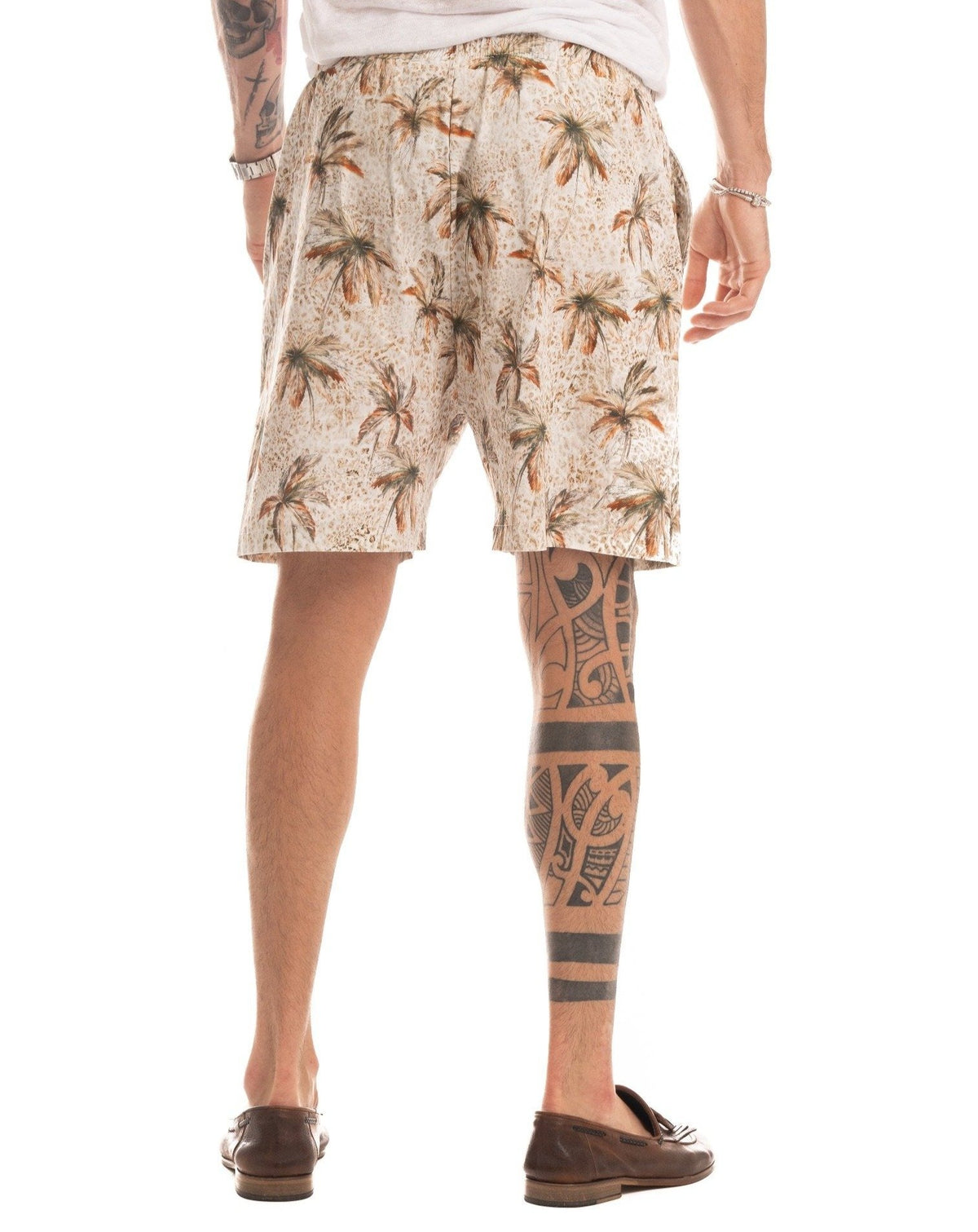 Beige palm tree print drawstring shorts with elastic waist, full-length view