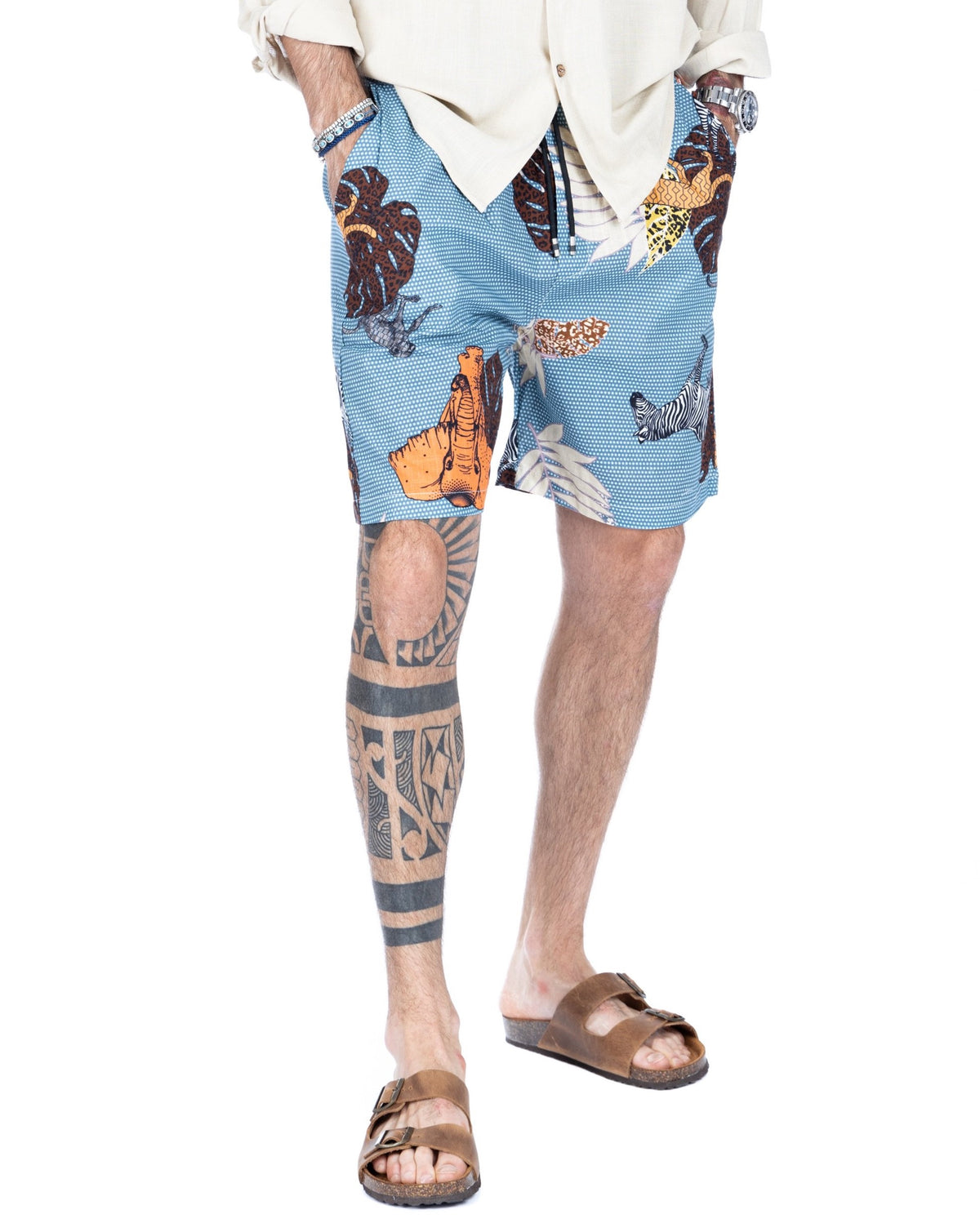 Men's light blue safari animal print drawstring shorts with elephant and zebra motifs, shown on a model