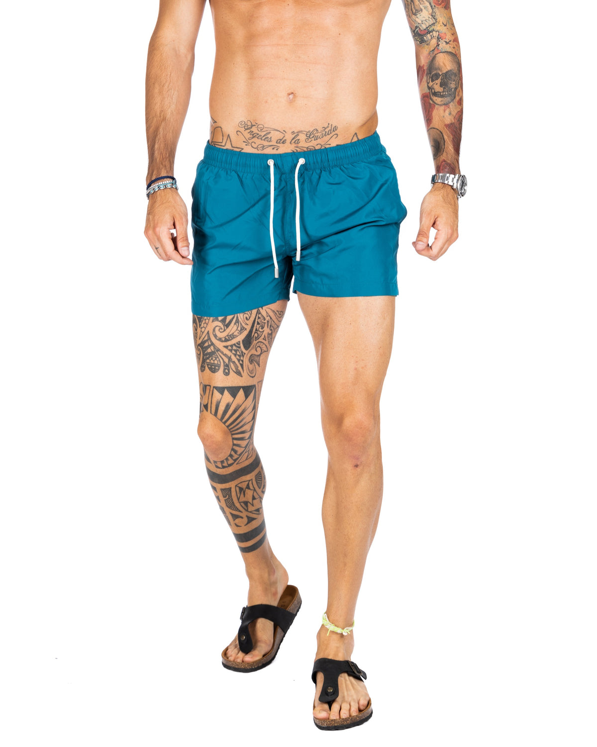 Men's teal blue swim shorts with white drawstring and elastic waistband, shown on a model