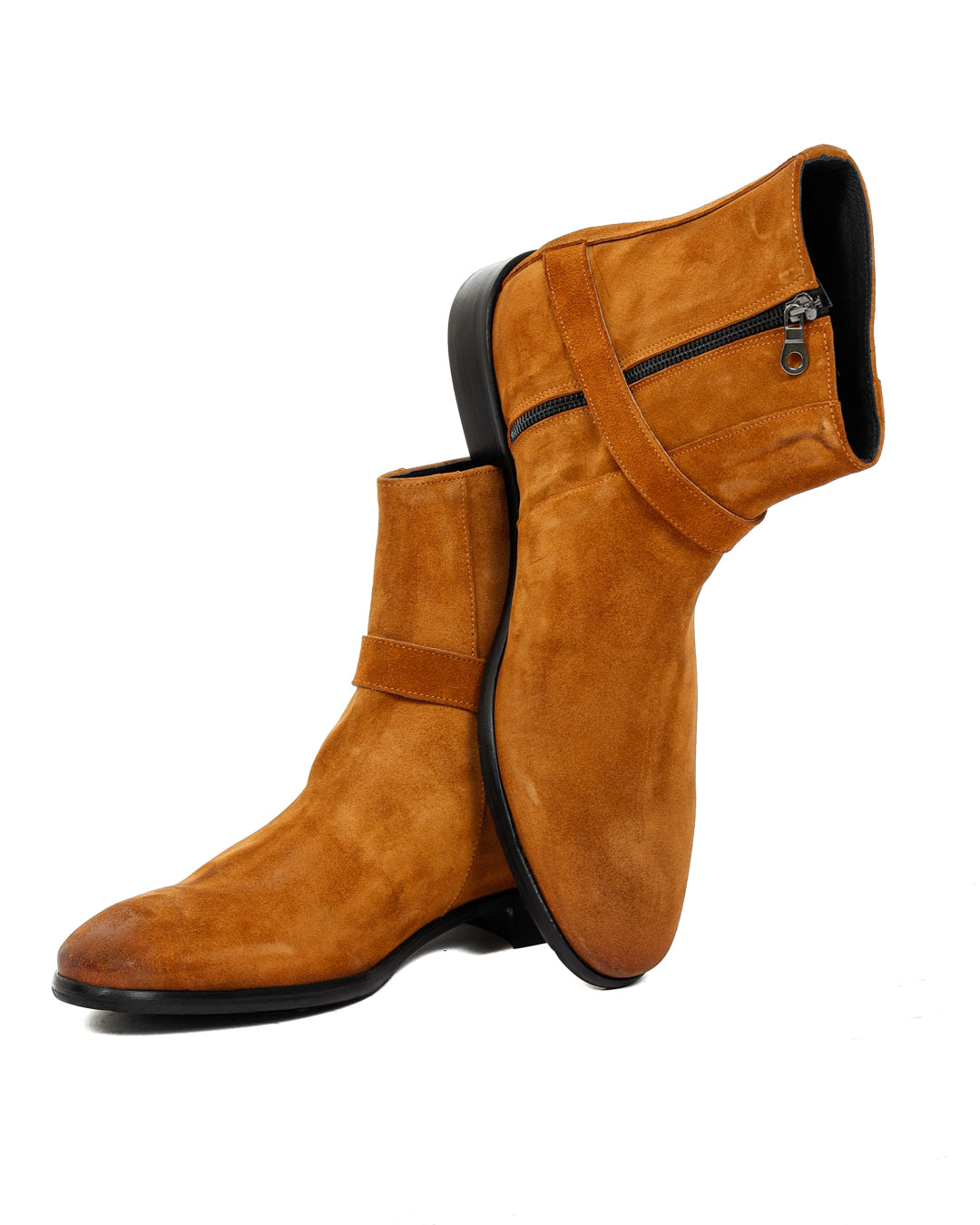 Pair of tan suede ankle boots stacked together with buckle straps on a white background
