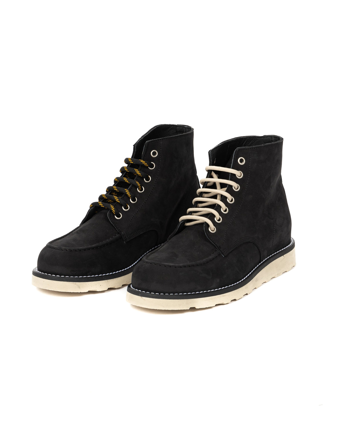 Black suede ankle boots with cream soles, featuring yellow and beige laces. Casual lace-up boot style.